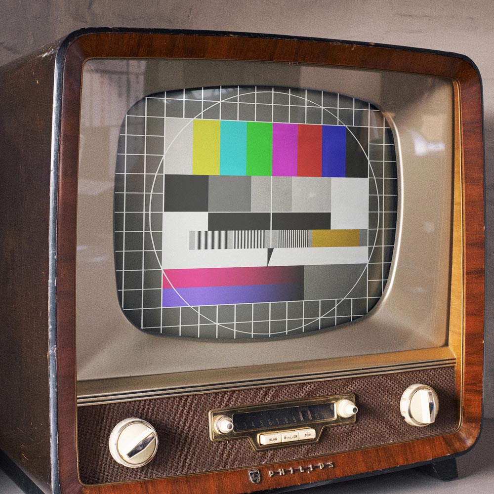 Ein alter Fernseher mit Holzrahmen zeigt ein Testbild in verschiedenen Farben und Mustern. Das Bild symbolisiert die Vielfalt und Qualität der angebotenen Leistungen.